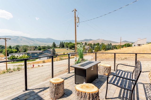 wooden deck featuring a mountain view, an outdoor fire pit, and a patio area