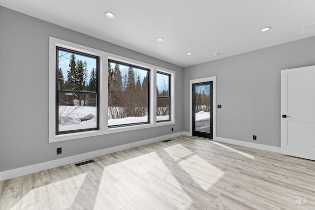 unfurnished room with baseboards, light wood-type flooring, recessed lighting, and visible vents