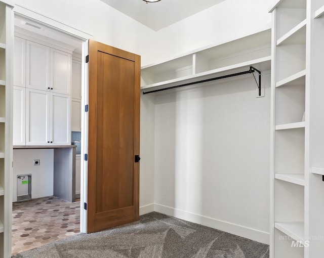 spacious closet with dark carpet