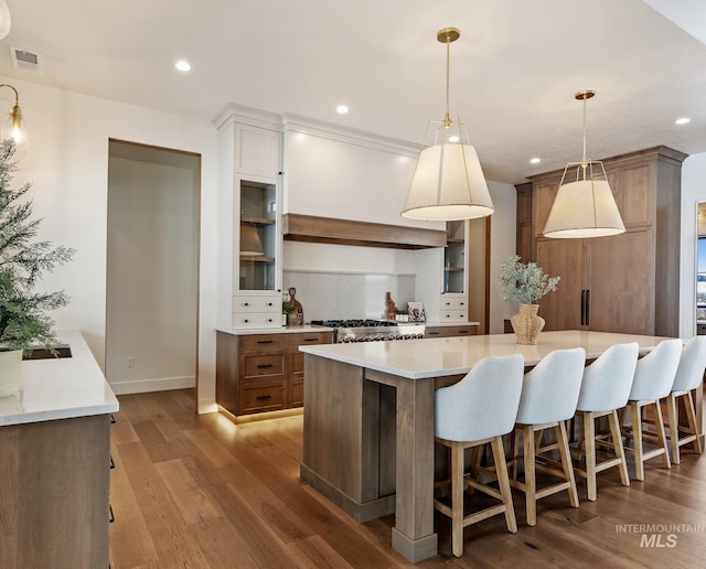 kitchen featuring recessed lighting, visible vents, decorative backsplash, and wood finished floors