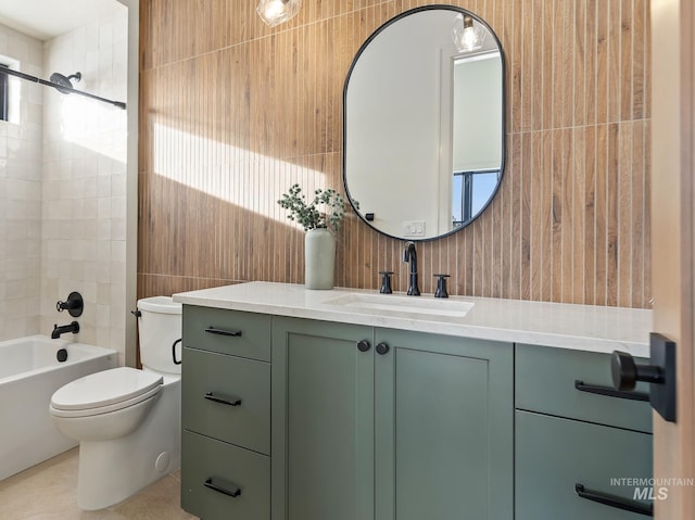 full bathroom with washtub / shower combination, vanity, tile patterned floors, toilet, and tile walls