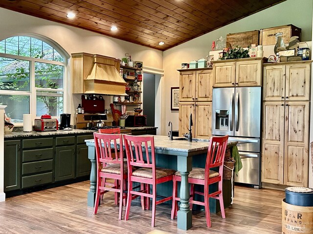 kitchen featuring lofted ceiling, light hardwood / wood-style floors, a center island with sink, and wooden ceiling