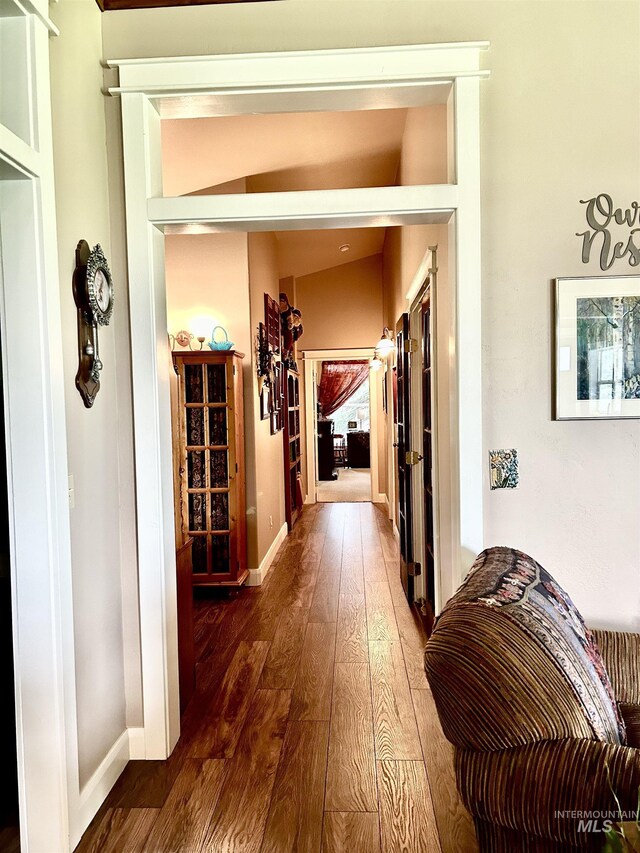 hall with wood-type flooring and lofted ceiling