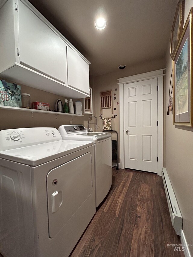 washroom featuring independent washer and dryer, dark hardwood / wood-style flooring, cabinets, and a baseboard heating unit