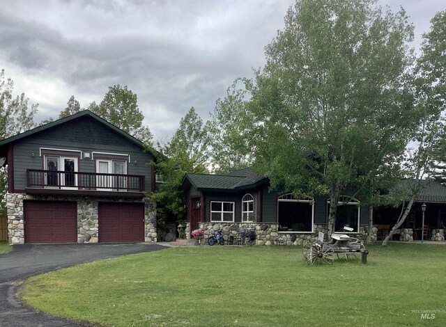 view of front of home with a balcony, a garage, and a front lawn