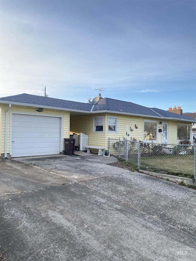 ranch-style house with a garage, fence, driveway, and a shingled roof