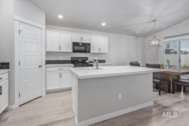 5144 W W Grand Rapids Dr, Meridian, ID 83646 - kitchen with black appliances, a sink, light wood-style floors, white cabinets, and recessed lighting