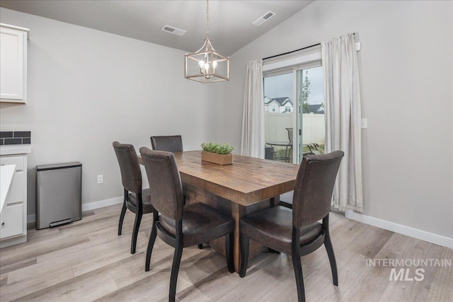 5144 W W Grand Rapids Dr, Meridian, ID 83646 - dining space with a chandelier, vaulted ceiling, light wood-type flooring, and baseboards