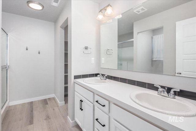 5144 W W Grand Rapids Dr, Meridian, ID 83646 - full bath featuring a shower with shower door, wood finished floors, double vanity, baseboards, and a walk in closet