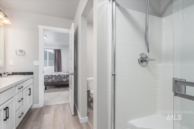 5144 W W Grand Rapids Dr, Meridian, ID 83646 - ensuite bathroom with wood finished floors, toilet, double vanity, and a stall shower