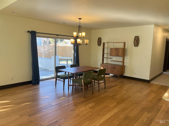 dining space featuring wood-type flooring and a chandelier