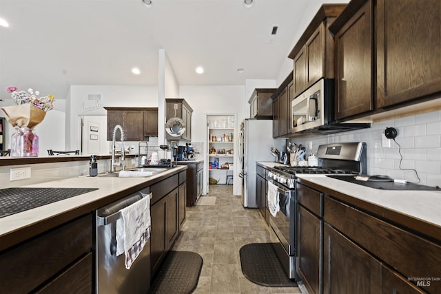 kitchen featuring dark brown cabinetry, stainless steel appliances, backsplash, and sink