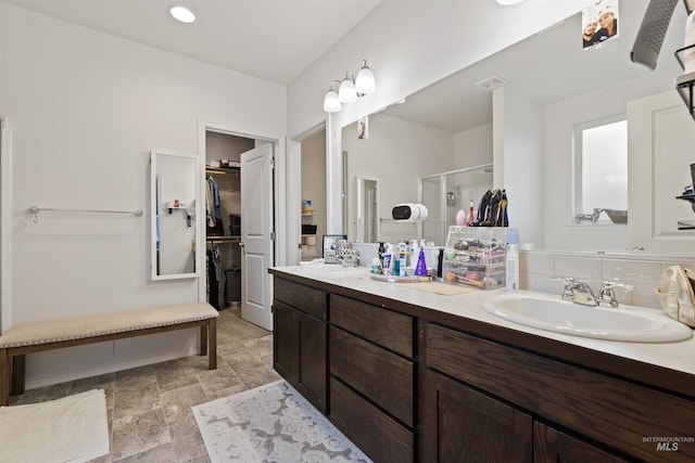 bathroom featuring vanity and a shower with door