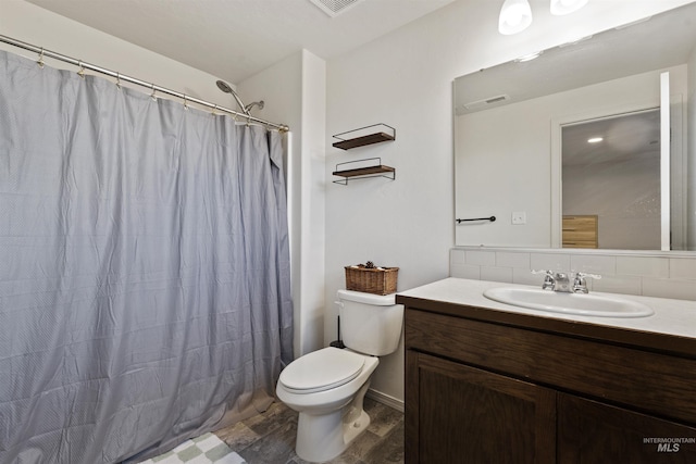 bathroom with hardwood / wood-style floors, vanity, toilet, walk in shower, and tasteful backsplash