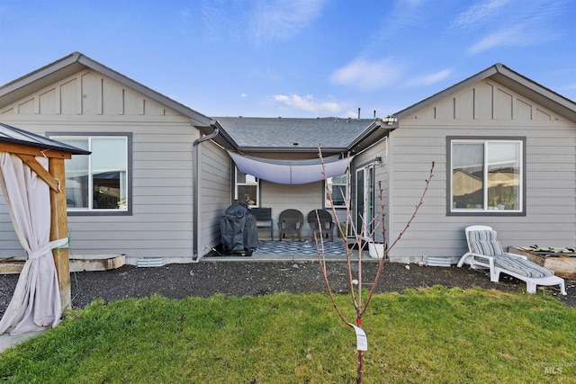 back of property with a patio area and a yard