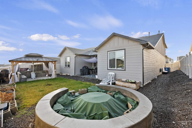 rear view of property with a gazebo and a yard