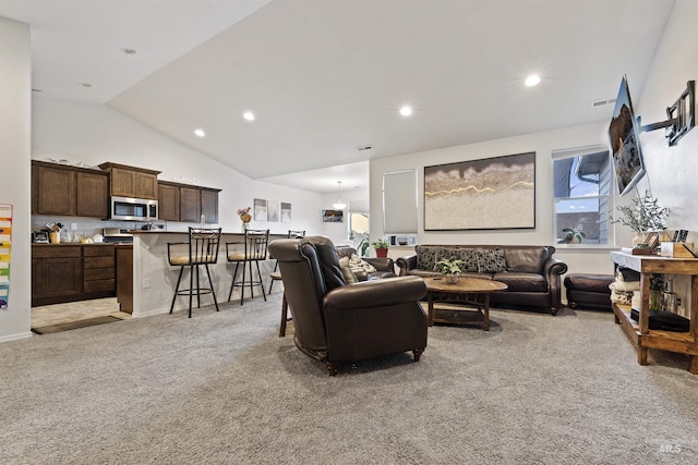 carpeted living room with vaulted ceiling