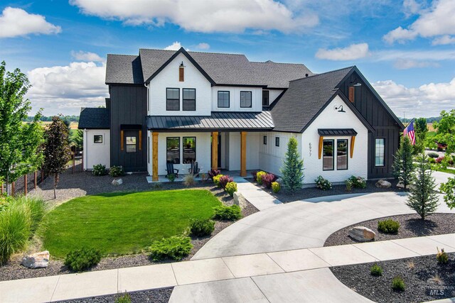 modern farmhouse style home with covered porch, a standing seam roof, board and batten siding, and a shingled roof