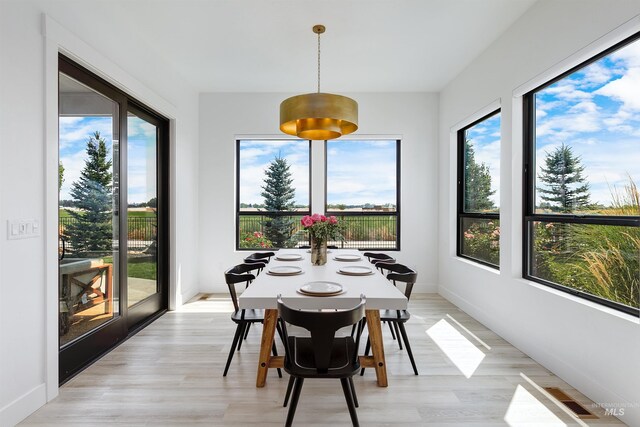 sunroom featuring healthy amount of natural light, wood finished floors, and baseboards
