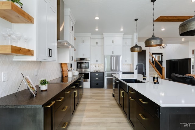 kitchen with appliances with stainless steel finishes, white cabinetry, a sink, dark cabinets, and recessed lighting