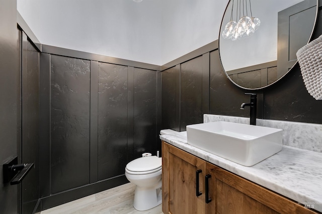 bathroom with vanity, toilet, and wood finished floors