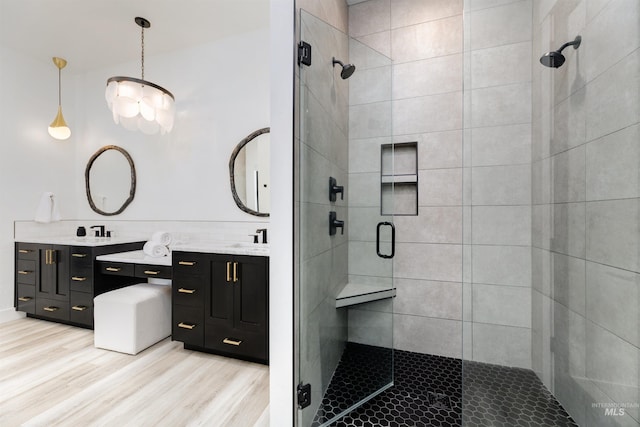full bathroom featuring a stall shower, vanity, and wood finished floors