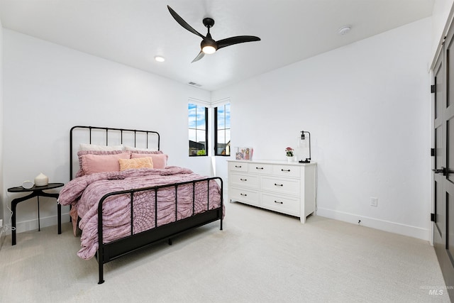 bedroom with light colored carpet, baseboards, and ceiling fan