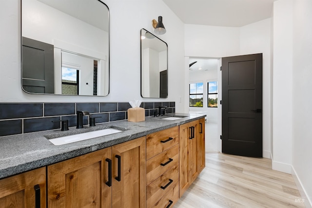 full bath with tasteful backsplash, wood finished floors, and double vanity
