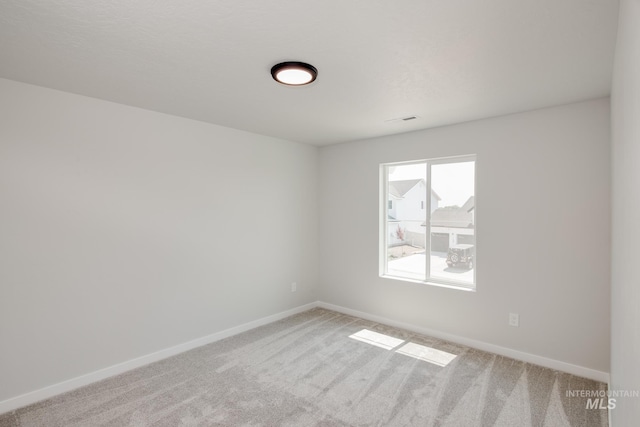 carpeted empty room featuring visible vents and baseboards