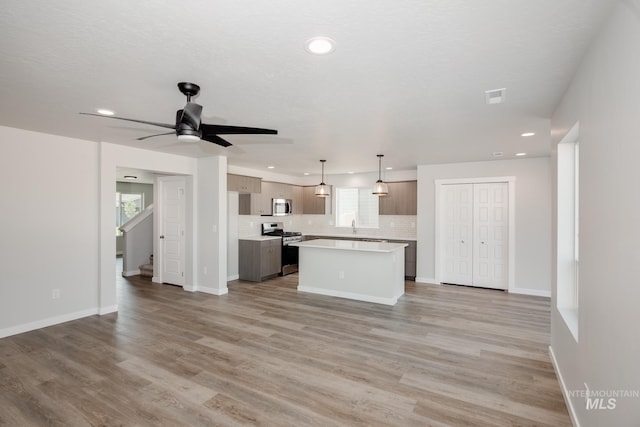 kitchen with stainless steel appliances, backsplash, a healthy amount of sunlight, and light countertops