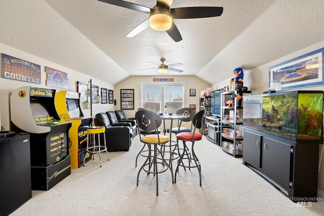 game room featuring a textured ceiling, ceiling fan, lofted ceiling, and carpet