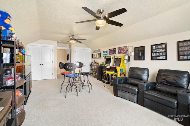 interior space with carpet floors, ceiling fan, a textured ceiling, and lofted ceiling