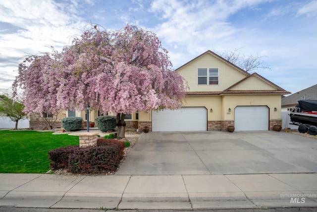 view of front of property featuring a front yard, an attached garage, stone siding, concrete driveway, and stucco siding