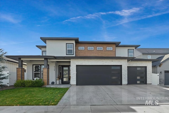 8749 W Suttle Lake Dr, Boise, ID 83714 - prairie-style house featuring driveway, stone siding, a garage, a front yard, and stucco siding