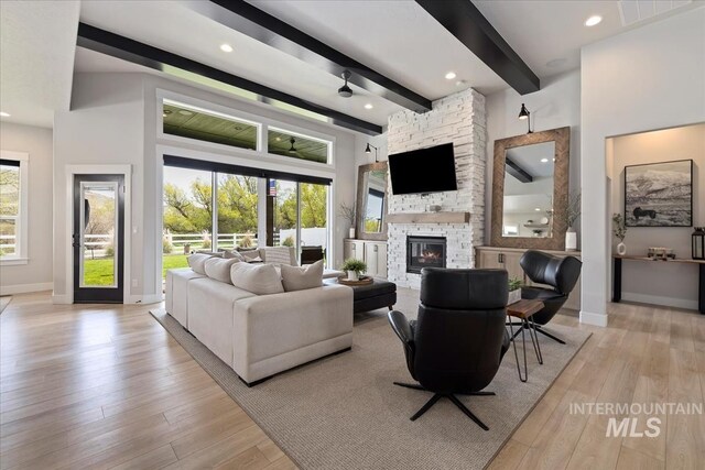 8749 W Suttle Lake Dr, Boise, ID 83714 - living area with beamed ceiling, a stone fireplace, visible vents, and light wood-type flooring