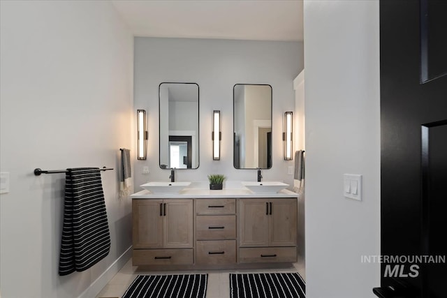 8749 W Suttle Lake Dr, Boise, ID 83714 - bathroom with double vanity, tile patterned flooring, baseboards, and a sink