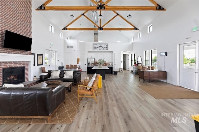8749 W Suttle Lake Dr, Boise, ID 83714 - living area with light wood-type flooring, beam ceiling, a brick fireplace, and high vaulted ceiling