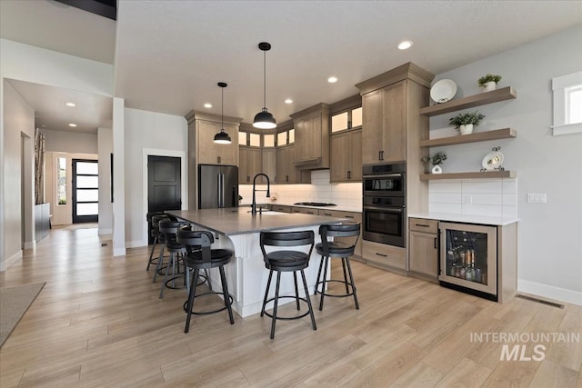 8749 W Suttle Lake Dr, Boise, ID 83714 - kitchen featuring gas cooktop, a kitchen breakfast bar, freestanding refrigerator, visible vents, and beverage cooler