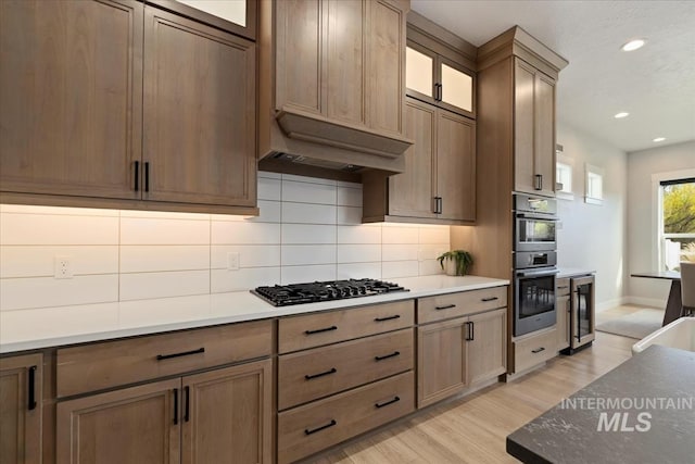 8749 W Suttle Lake Dr, Boise, ID 83714 - kitchen with recessed lighting, beverage cooler, black gas cooktop, light wood finished floors, and decorative backsplash