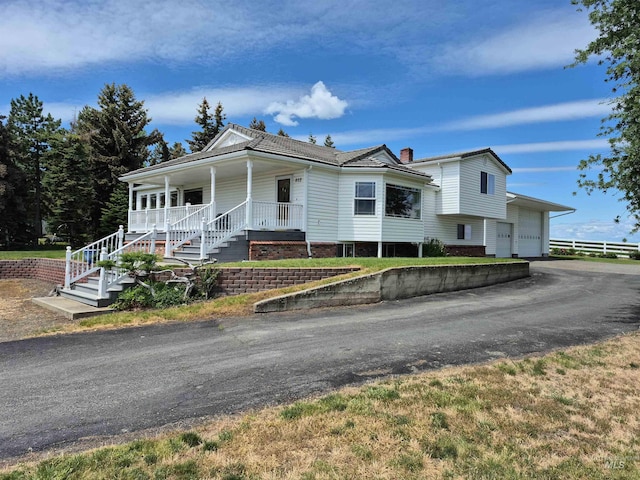 802 Foster Ave, Cottonwood, ID 83522 - view of front facade featuring covered porch, stairway, driveway, an attached garage, and a chimney