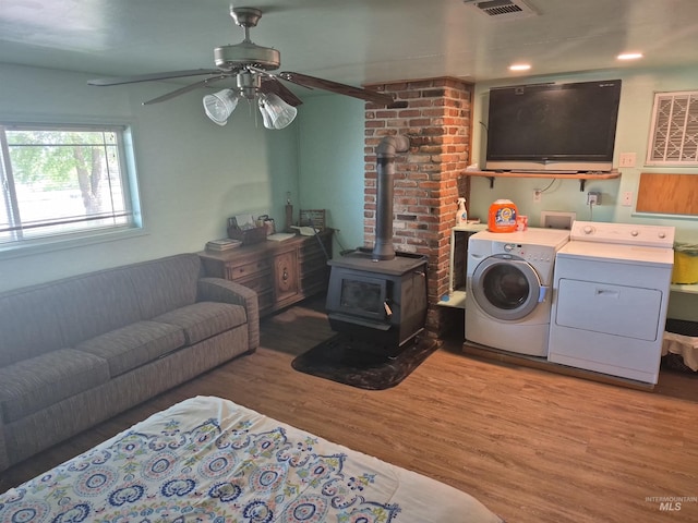 802 Foster Ave, Cottonwood, ID 83522 - laundry area with washing machine and dryer, a wood stove, a ceiling fan, and light wood-type flooring