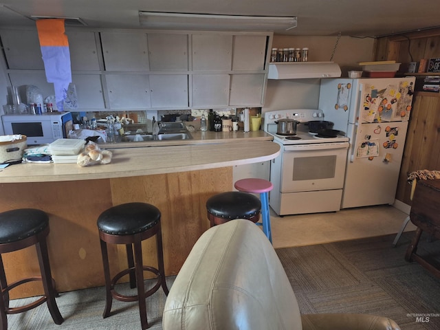 802 Foster Ave, Cottonwood, ID 83522 - kitchen with white appliances, ventilation hood, a kitchen breakfast bar, and light countertops