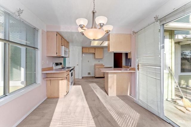 kitchen featuring white appliances, light brown cabinets, a wealth of natural light, and light colored carpet