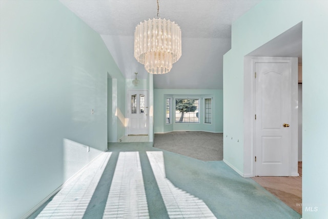 interior space with carpet flooring, vaulted ceiling, baseboards, and an inviting chandelier