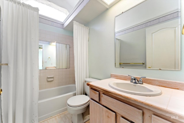 bathroom with a skylight, toilet, wood finished floors, shower / bath combo with shower curtain, and vanity