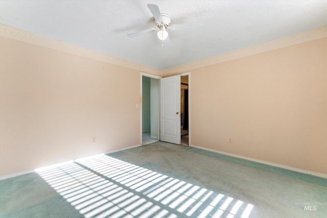 unfurnished room with baseboards, ornamental molding, a ceiling fan, and light colored carpet