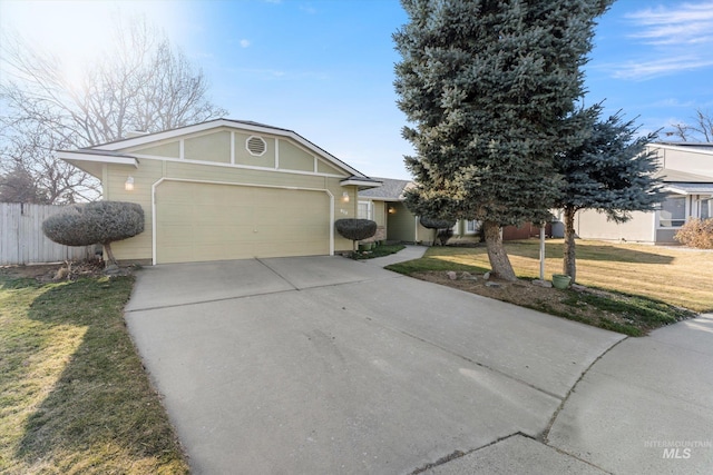 view of front facade with a garage, driveway, a front lawn, and fence