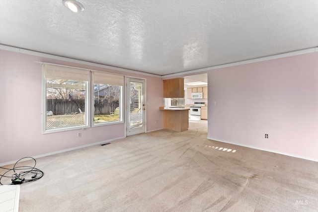 unfurnished living room with a textured ceiling, light colored carpet, visible vents, baseboards, and ornamental molding