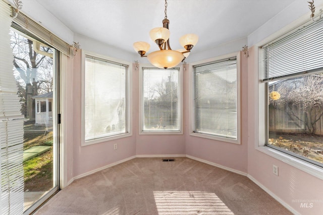 unfurnished dining area featuring a notable chandelier, visible vents, baseboards, and carpet flooring