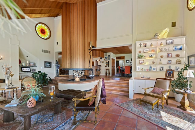 dining room with tile patterned floors, wood ceiling, and a high ceiling